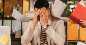 A stressed professional reviewing rejected grant proposal paperwork