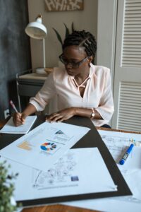 A young African entrepreneur writing a funding proposal at her desk