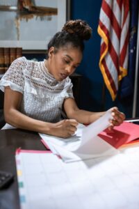 Nonprofit finance officer reviewing a grant budget narrative at an office desk