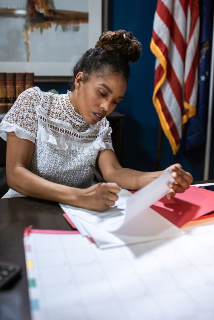 Nonprofit finance officer reviewing a grant budget narrative at an office desk